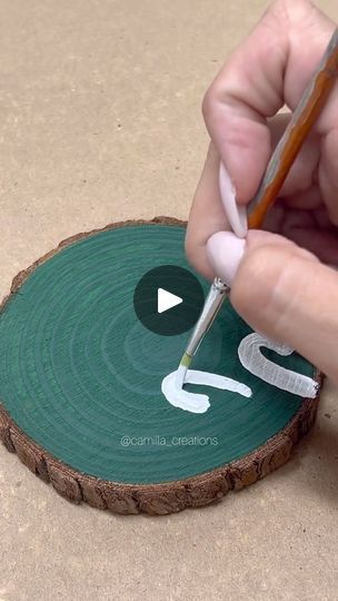 a person is using scissors to cut out the numbers on a piece of wood that has been painted green