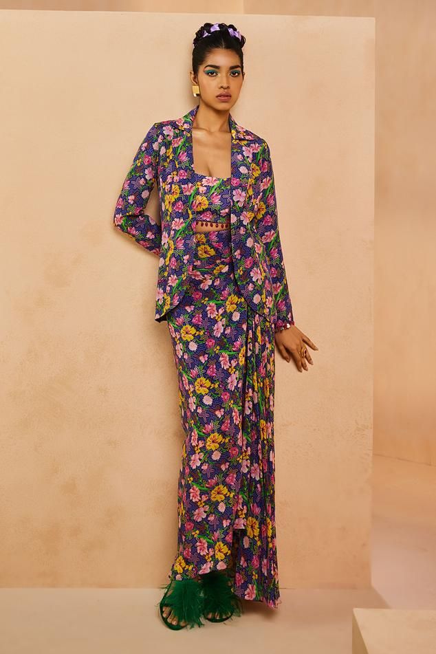 Purple blazer featuring a ditsy floral print, notched lapel collar, and full sleeves. Paired with a padded bustier and dhoti skirt, both adorned with the same floral design., Fit: Relaxed Dhoti Skirt, Bustier Blouse, Floral Print Blazer, Purple Blazer, Open Blazer, Women Skirt, Blazer Set, Ditsy Floral Print, Printed Blazer