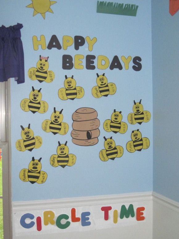 a room with a blue wall decorated with cartoon bees and the words happy beeday's circle time