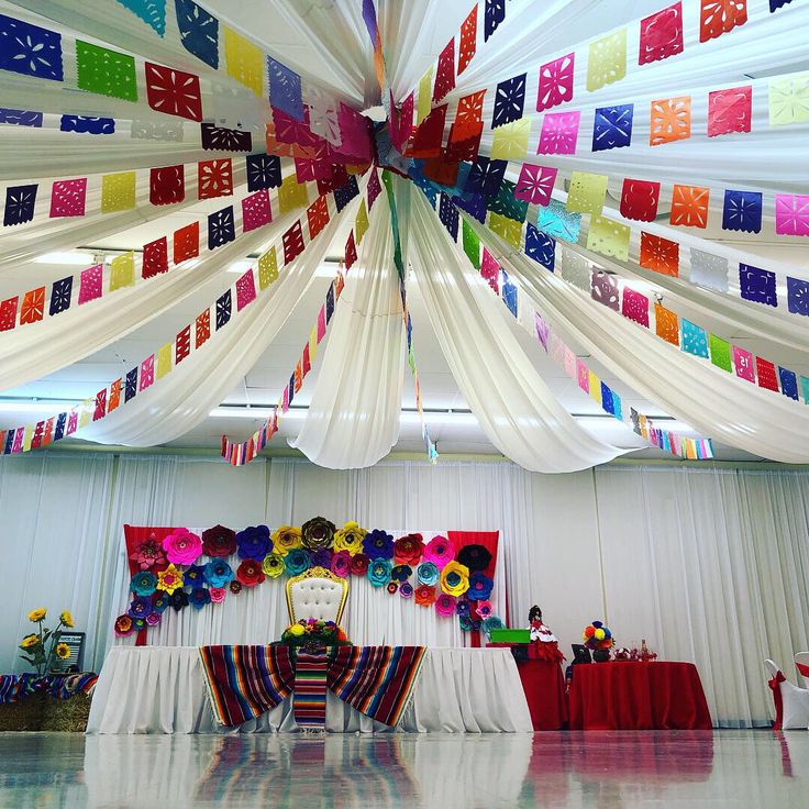 colorful streamers are hanging from the ceiling above a banquet table set up for an event