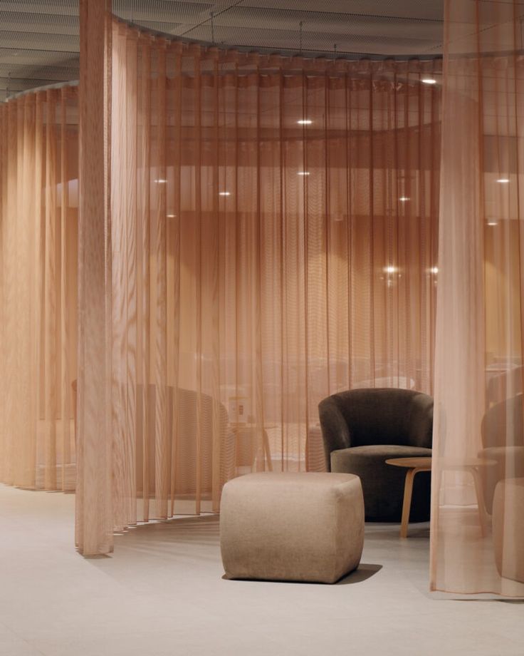 a room with sheer curtains and furniture in the corner, along with a round table