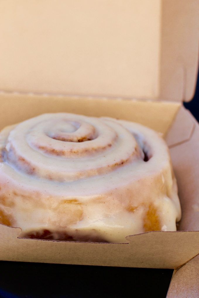 a close up of a doughnut in a box with icing on it's surface