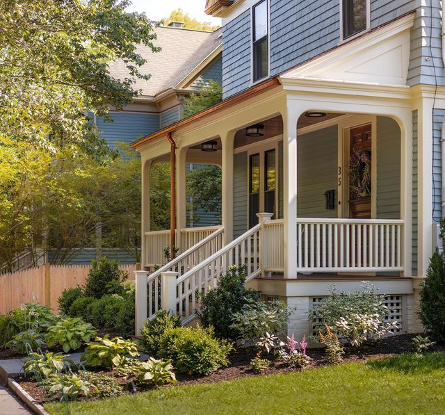 the front porch of a house with landscaping around it