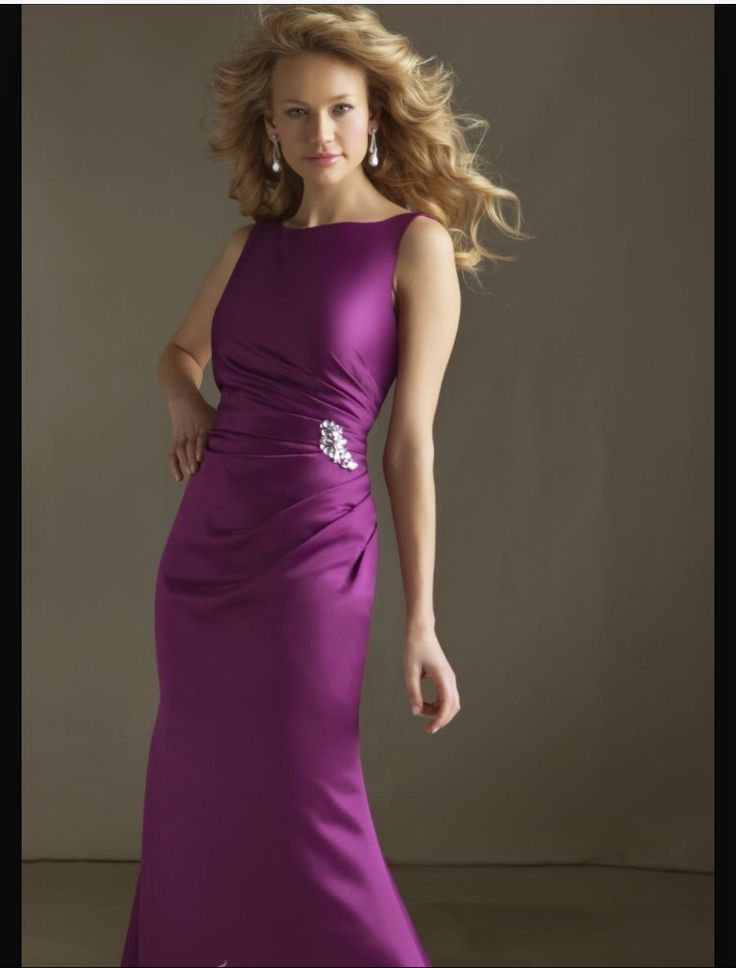 a woman in a long purple dress posing for the camera with her hand on her hip