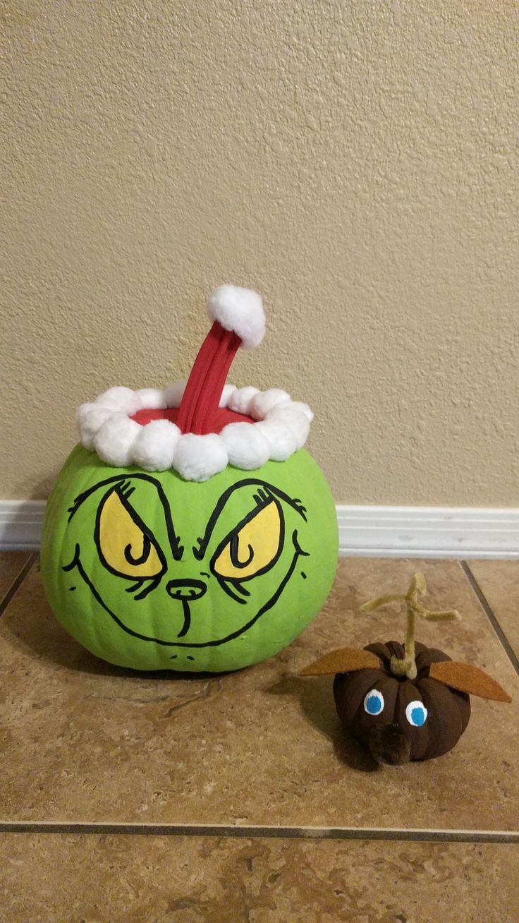 a grin face pumpkin sitting on the floor next to a toy