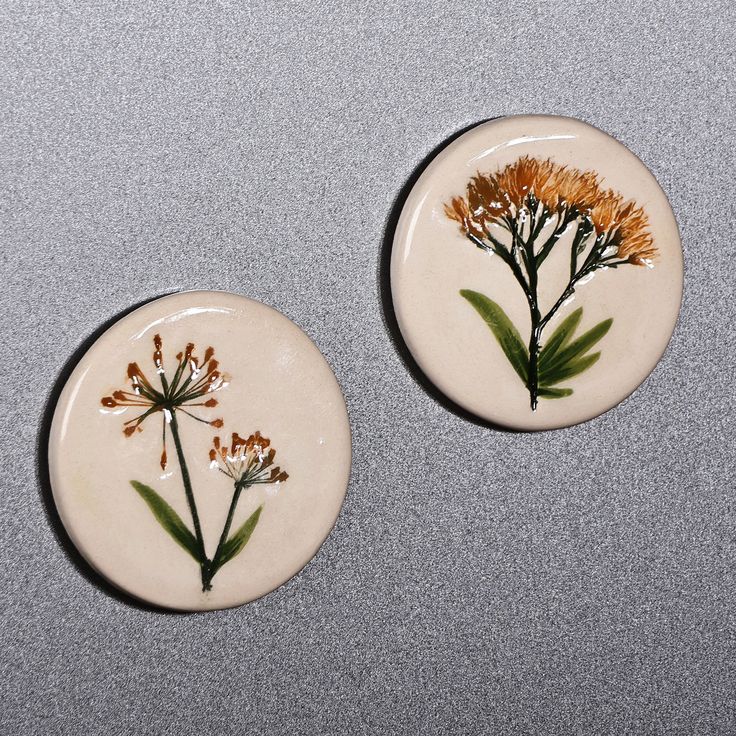 two small plates with flowers painted on them