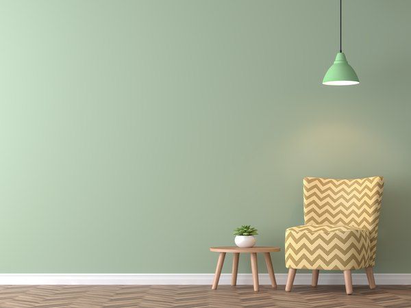 an empty room with a chair, table and potted plant on the floor next to it