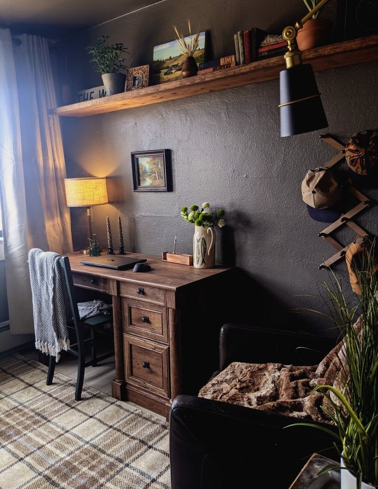 a living room filled with furniture next to a window and potted plants on top of a wooden desk