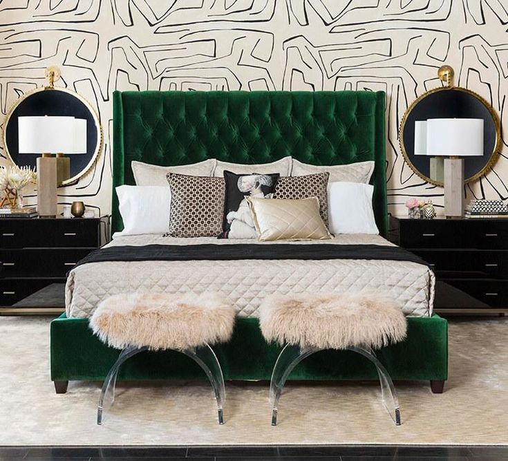 a bedroom with green velvet headboard and foot stools in front of the bed