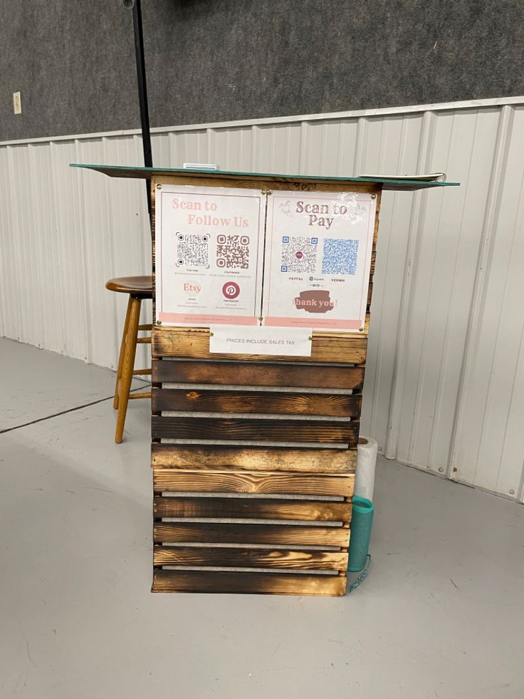 a wooden stand with two menus on top of it next to a blue trash can