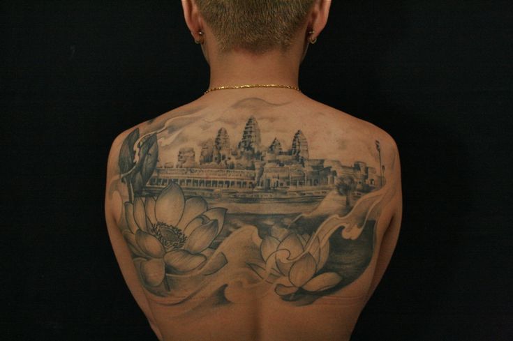 the back of a man's body with tattoos on it