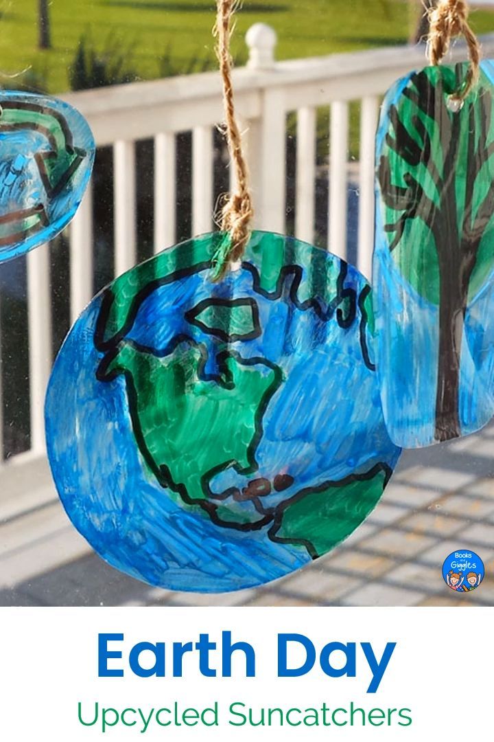 an earth day craft hanging from a white fence