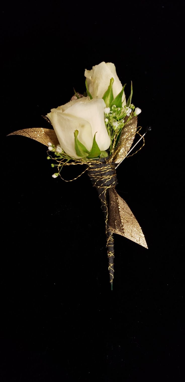 a bouquet of white roses and greenery on a black background with the stems still attached