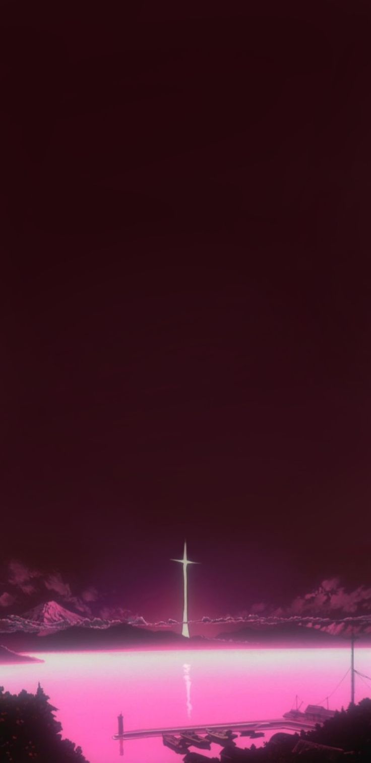 an image of a cross in the distance with pink sky and water behind it at night