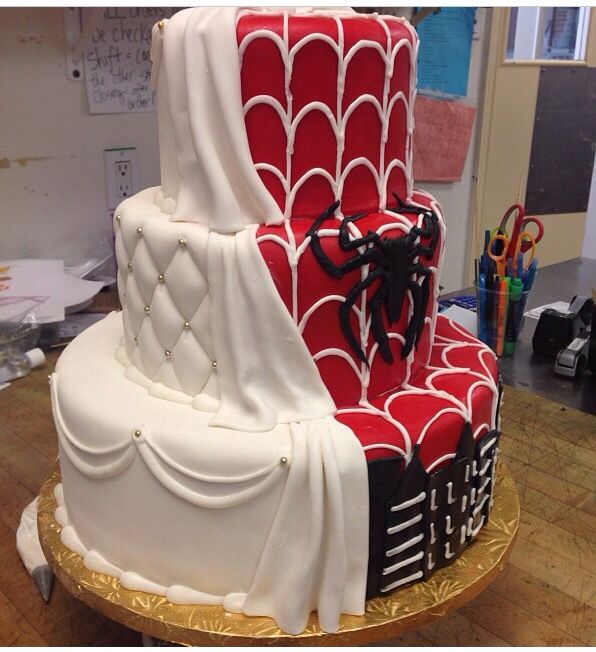 two tiered cake decorated with white and red designs