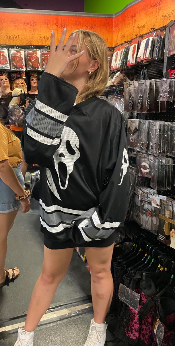 a woman standing in front of a store display with her hand up to her face