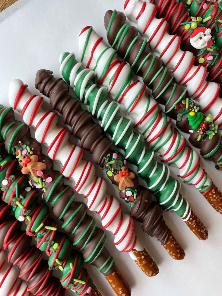 many candy canes are lined up on a white surface and decorated with christmas decorations