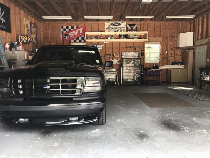 a truck is parked in a garage with other vehicles