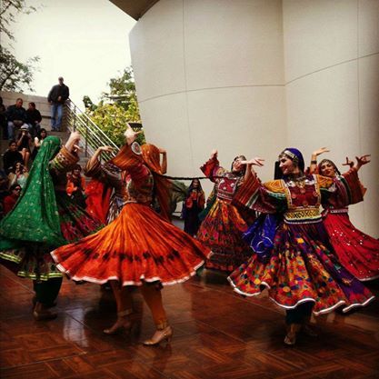 several women in colorful dresses dancing on a wooden floor