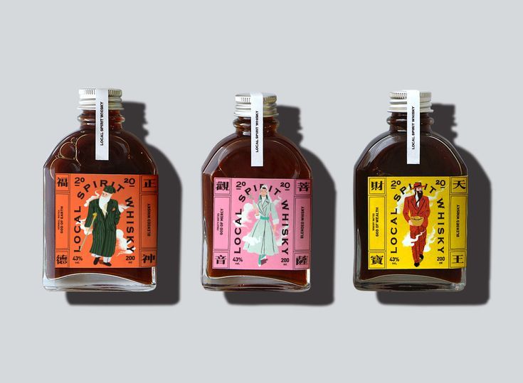 three bottles of syrup with labels on each one and the same label in different colors