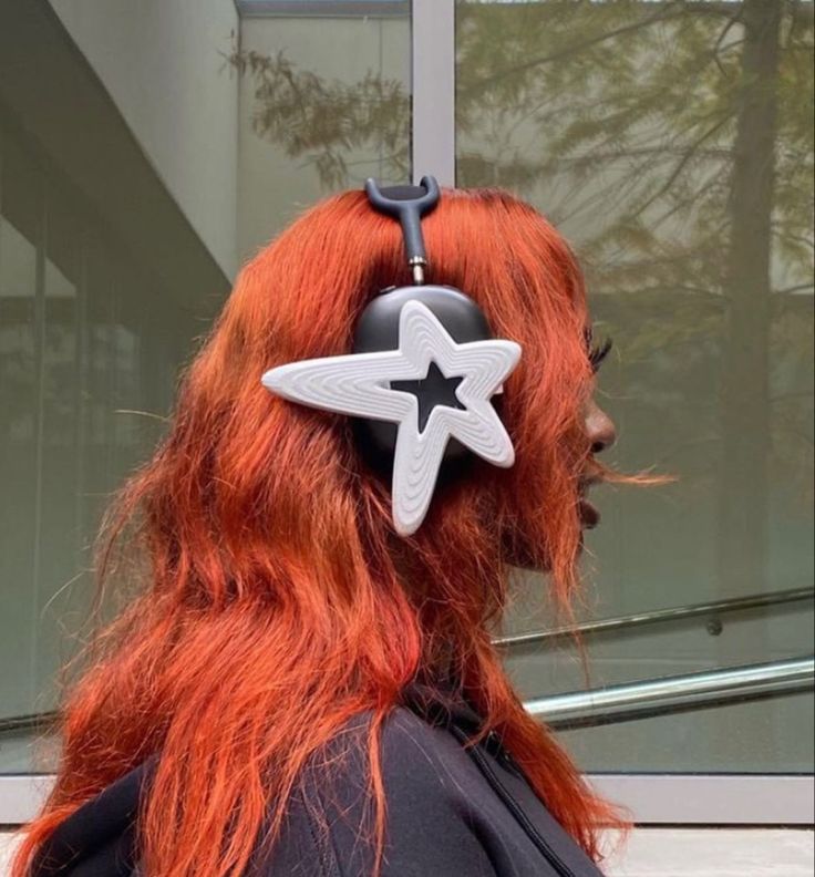 a woman with red hair wearing a pair of scissors on her head