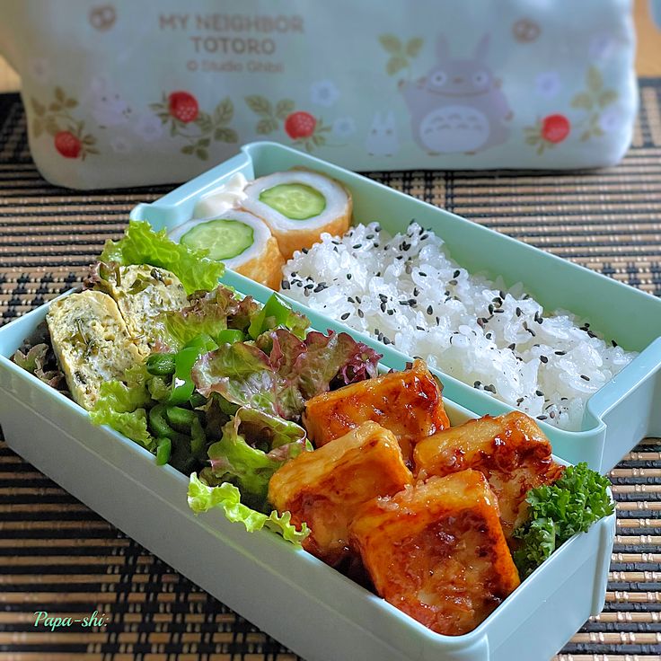 there is a bento box with rice and vegetables in it, along with other food items