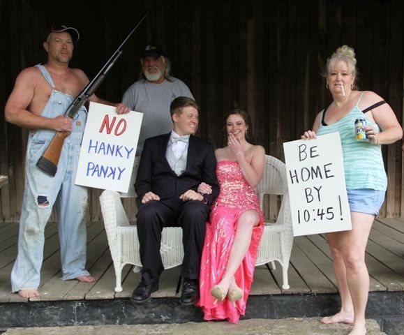 a group of people holding signs and posing for the camera with one woman in a pink dress