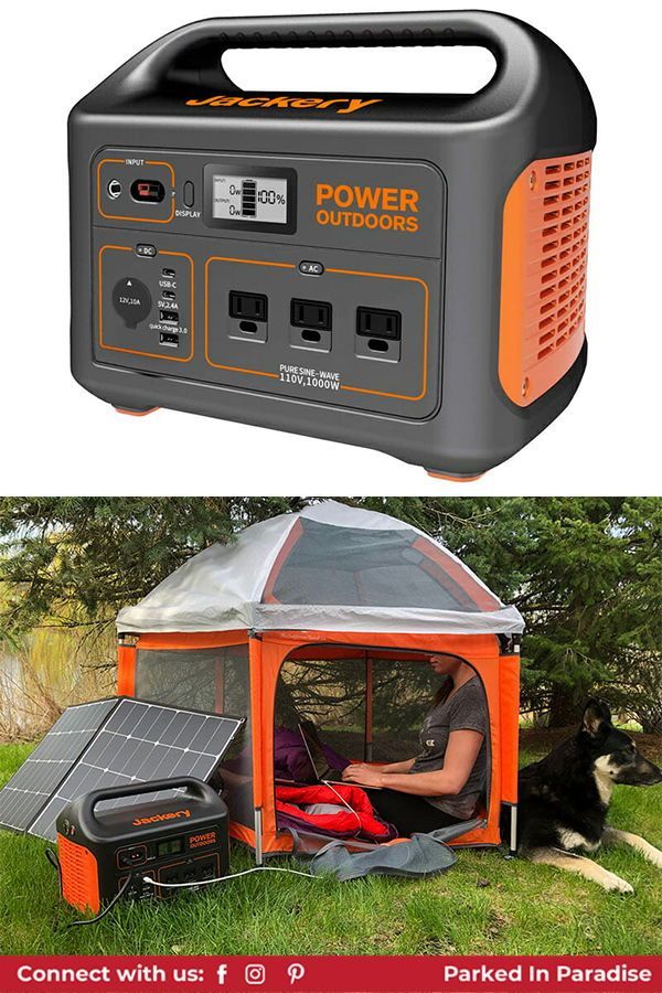 an orange and black portable generator sitting in the grass next to a dog laying down