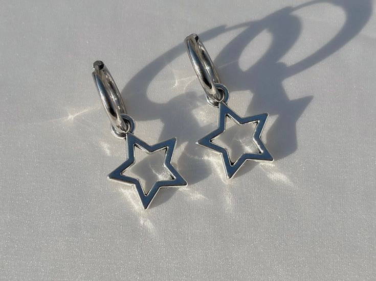 Lovely silver huggie earrings with large stars These earrings are a true silver staple for anyone's collection! They will go with absolutely anything anytime! Wear them everyday for a casual feel or dress them up anyway to add some style! *LENGTH- 3.4cm *DROP LENGTH- 1.7cm *EARRING WIDTH- 14mm ♡ All earring clasps in my store are hypoallergenic / nickel free ♡ Some parts of these earrings are nickel free, please contact for details ♡ All the jewelry in my store is handmade by me! ♡ For longer we Cute Star Earrings, Star Earrings Aesthetic, Black And Silver Earrings, Grunge Earrings, Y2k Alt, Funky Accessories, Y2k Earrings, Silver Jewlery, Alt Goth