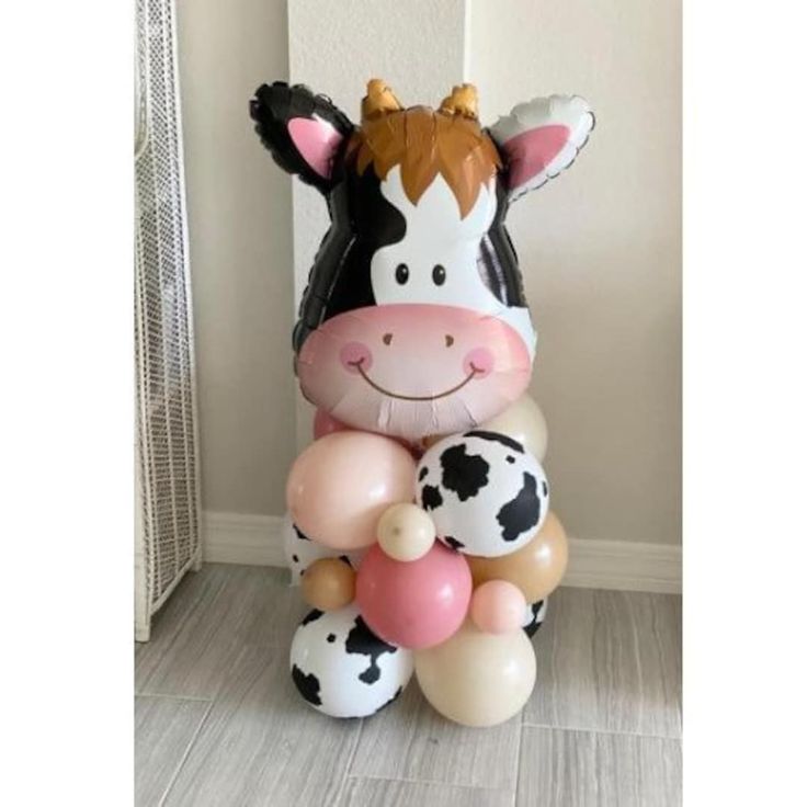 a cow balloon sitting on top of a floor