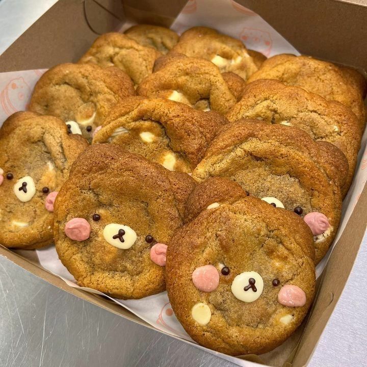 a box filled with chocolate chip cookies covered in teddy bears'eyes and nose noses