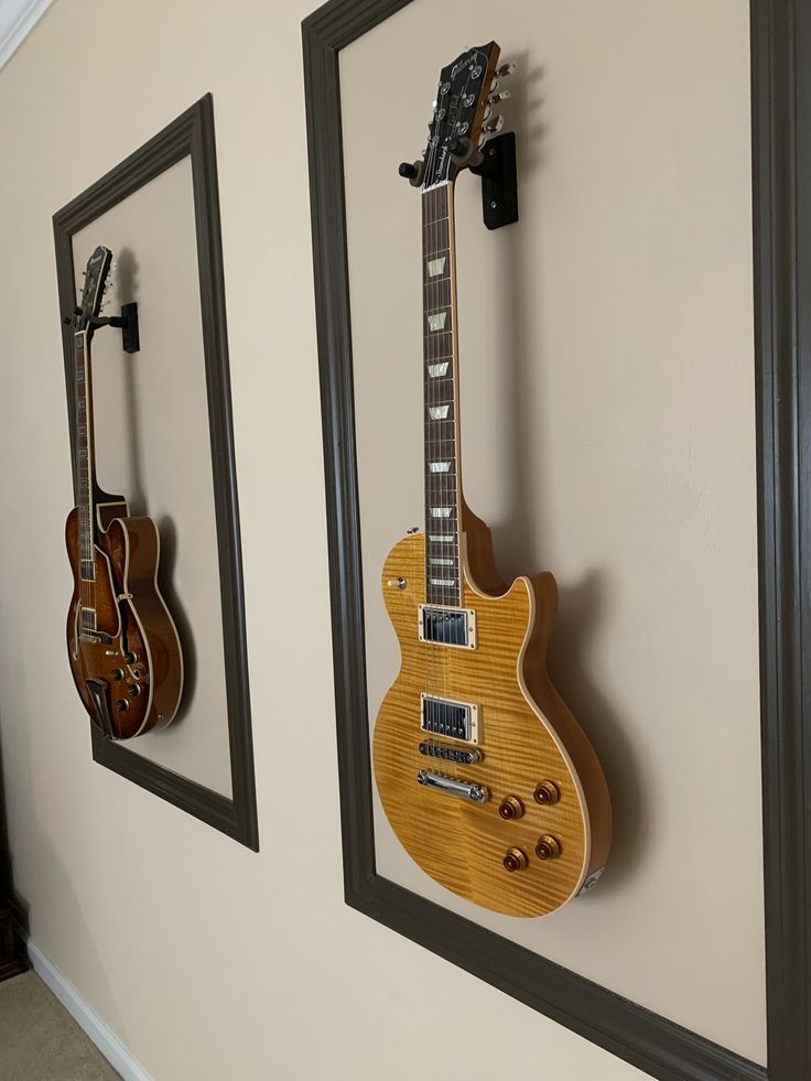 two guitars are hanging on the wall next to each other