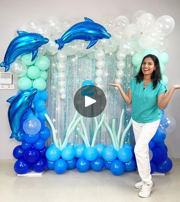 a woman standing in front of balloons and dolphins