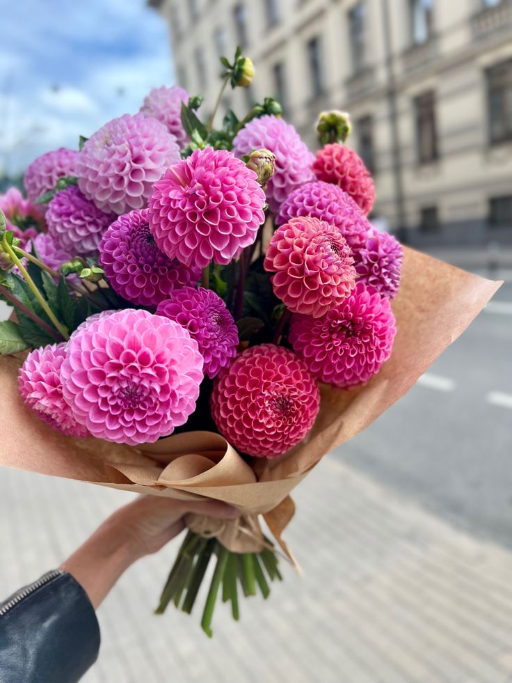 a person holding a bouquet of pink flowers