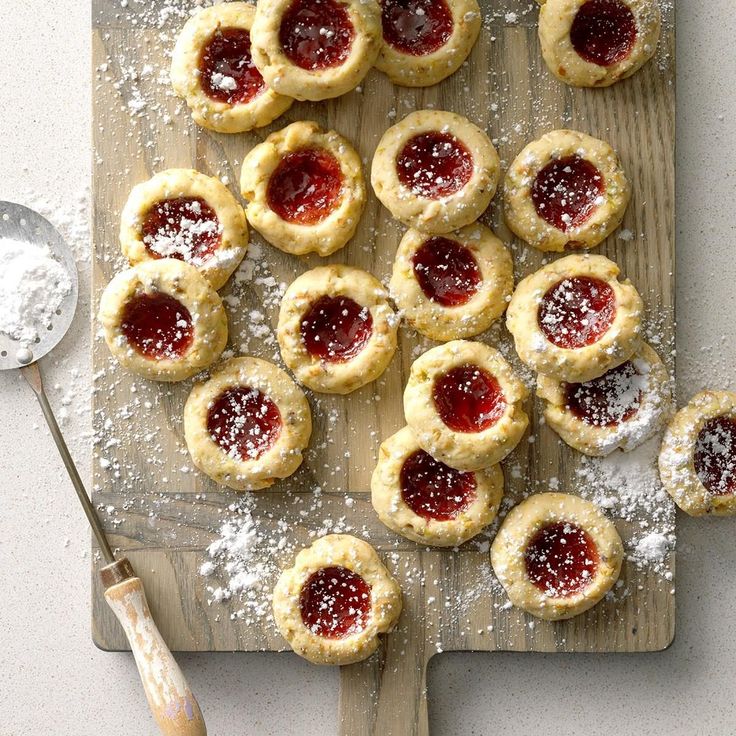 small pastries on a cutting board with powdered sugar and spoons next to them