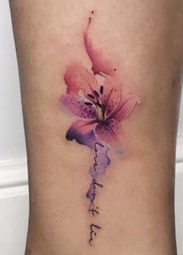 a woman's lower leg with a pink flower tattoo on her left side ribcage