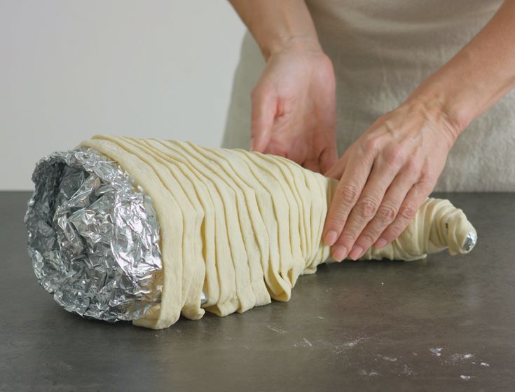 a woman is wrapping something in tin foil