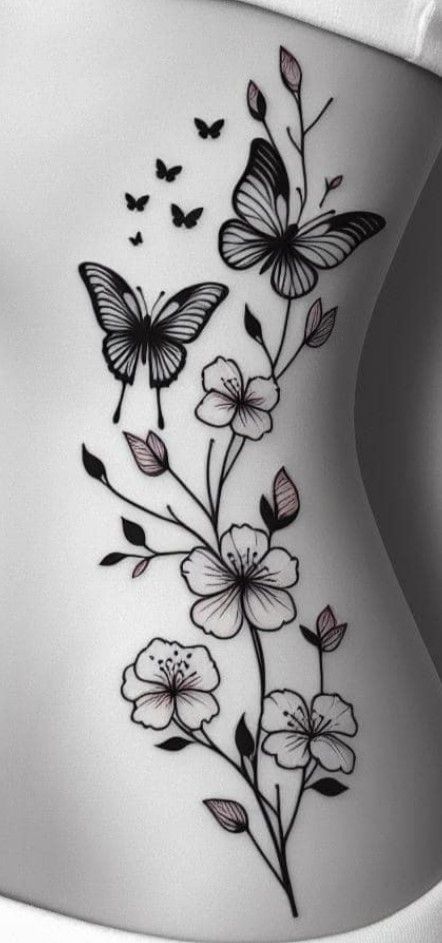 a woman's stomach with butterflies and flowers on the side, in black and white