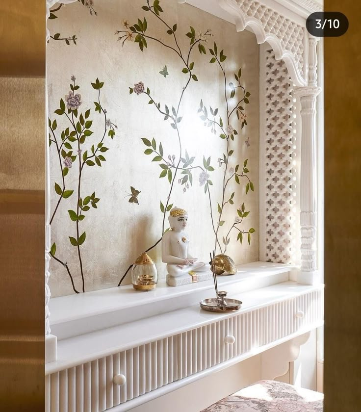 a white shelf with flowers on it in front of a wallpapered window sill