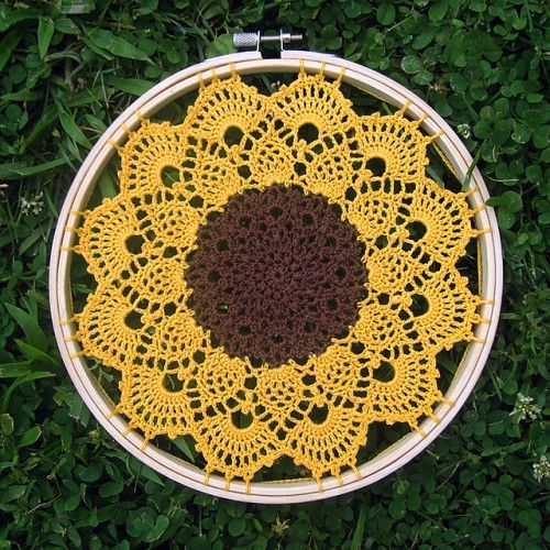 a yellow and brown doily sitting in the grass