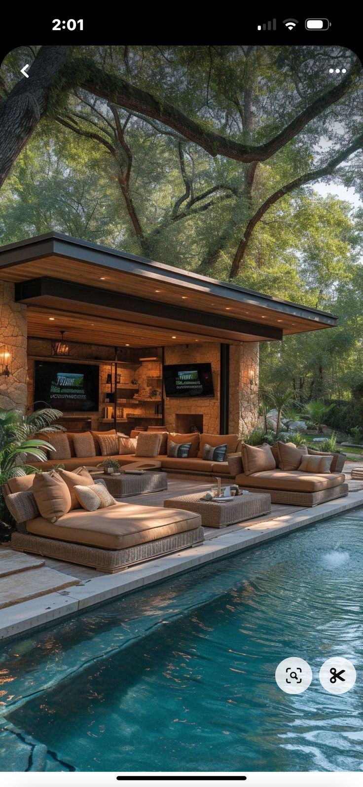 an outdoor living area next to a swimming pool with couches and tables on it