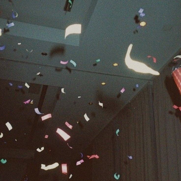 confetti falling down from the ceiling in a room with black walls and ceilings