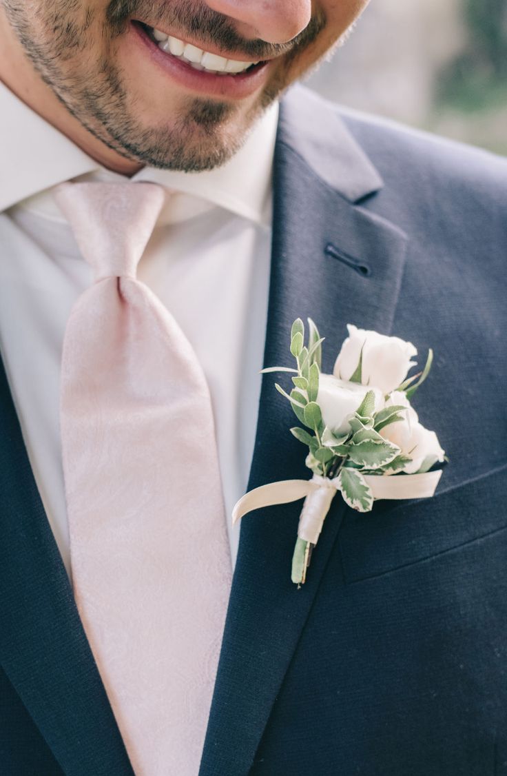 a man in a suit and tie with a boutonniere on his lapel