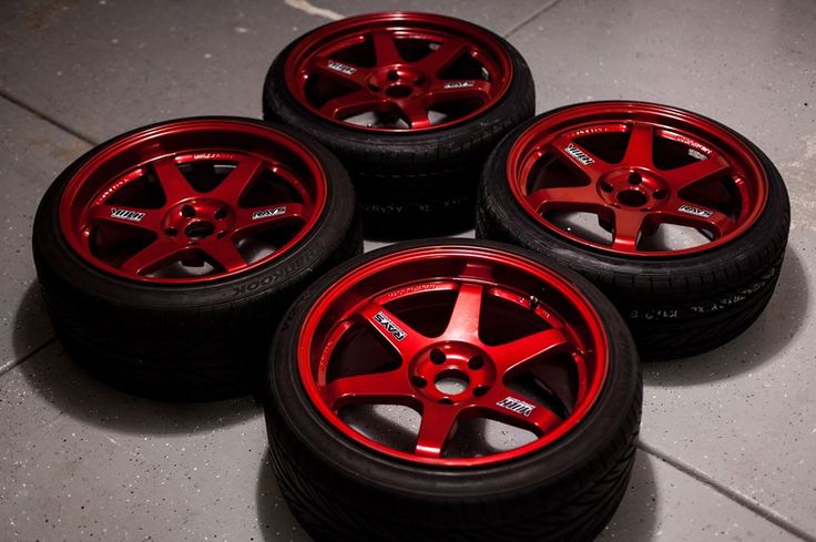 four red rims and tires on the ground