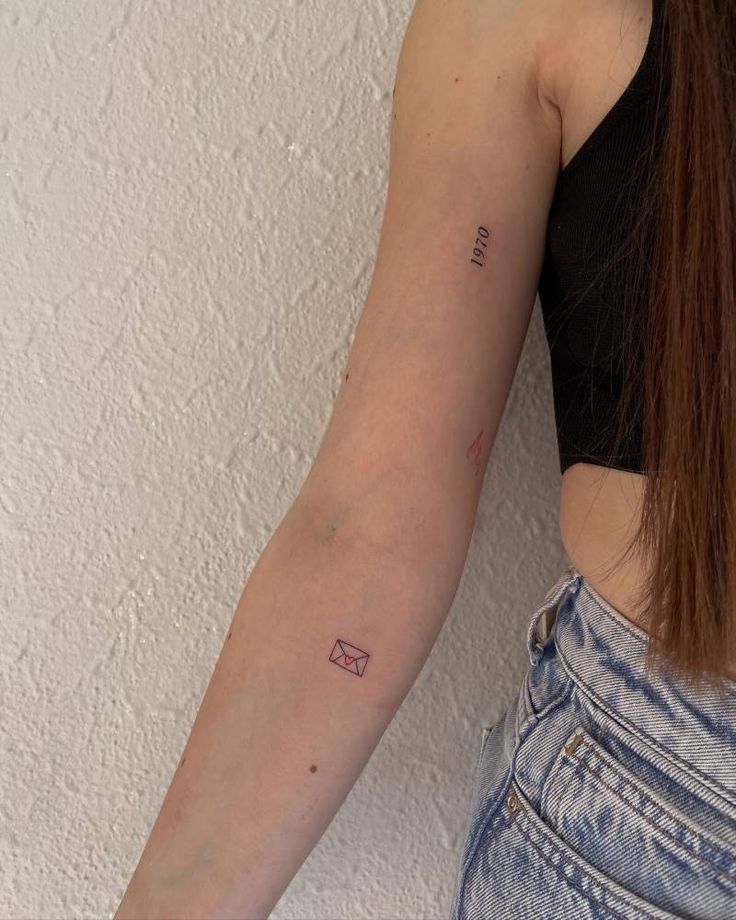 a woman's arm with a small tattoo on the left side of her arm