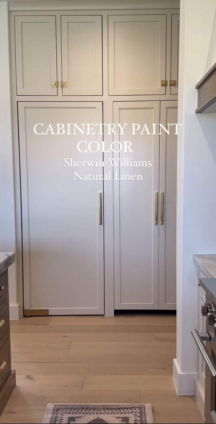 a kitchen with white cabinets and wood floors