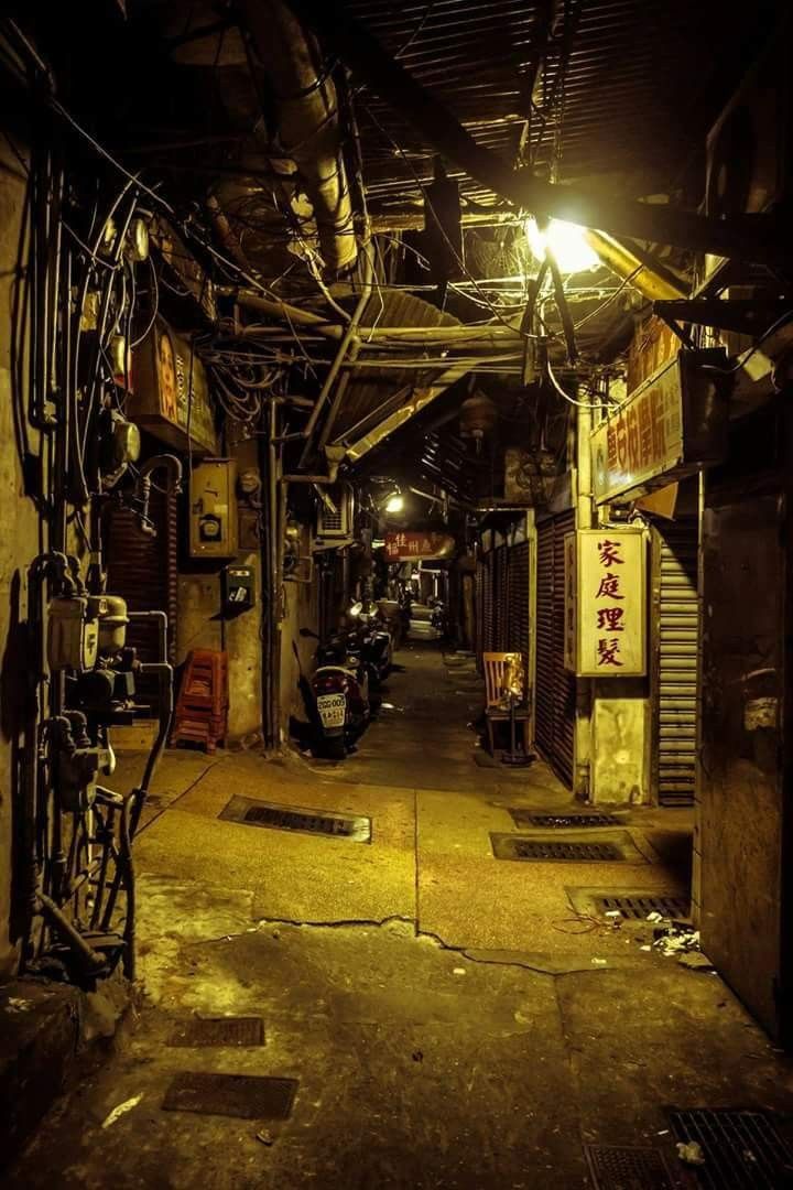 an alley way with scooters parked on the sides and signs hanging from the ceiling