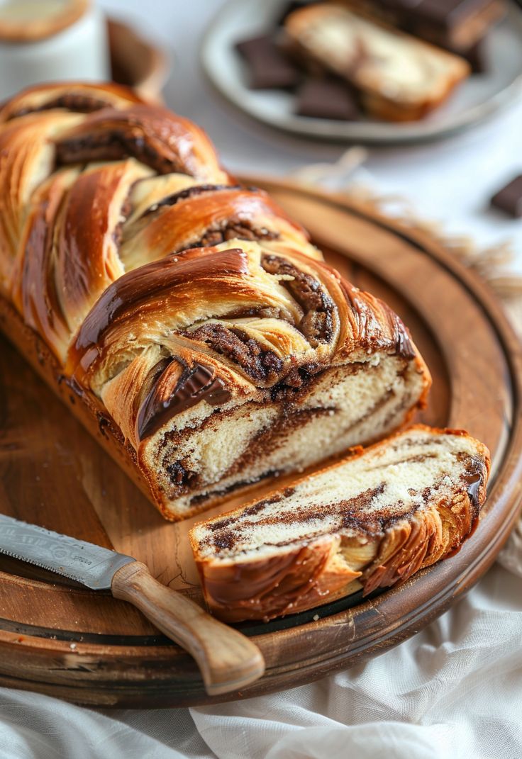 a loaf of cinnamon swirl bread sitting on top of a wooden platter