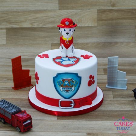 there is a cake with a fireman on top and a toy truck next to it