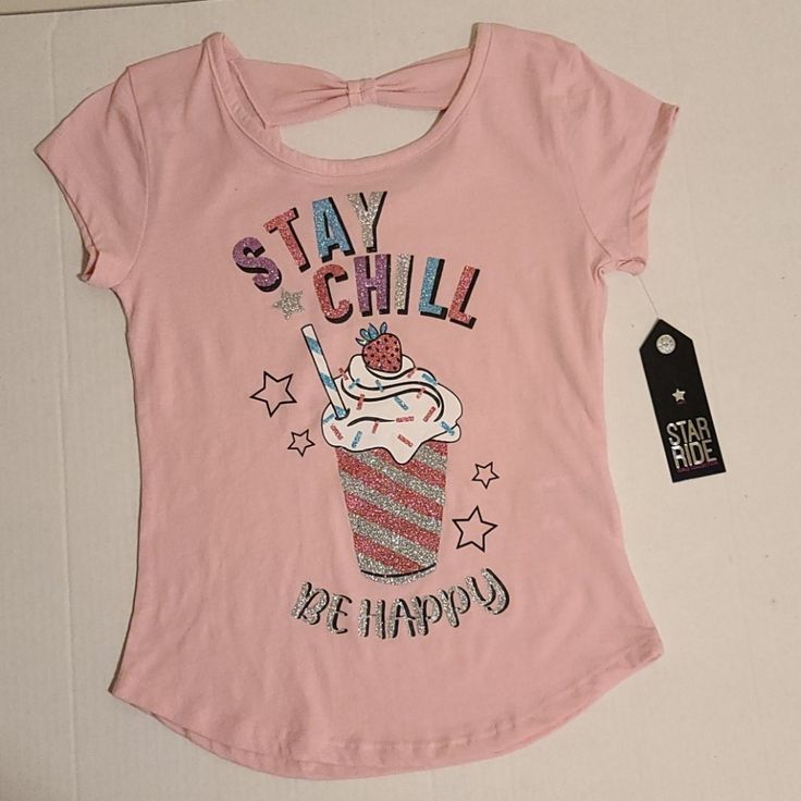 Cute Girls Top Features Short Sleeves, A Stay Chill Glittery Graphic Design, And A Bow On Upper Back. 60% Cotton And 40% Polyester. Machine Wash. Casual Pink T-shirt With Glitter Print, Casual Glitter Print Tops For Spring, Casual Glitter Print T-shirt For Spring, Casual T-shirt With Glitter Print, Casual Summer Tops With Glitter Print, Cute Glitter Print Short Sleeve Tops, Cute Short Sleeve Tops With Glitter Print, Pink Glitter Print Top For Summer, Pink Casual Top With Glitter Print